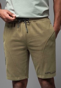 Oliven grønne sweatshorts lavet af blødt stof, med elastisk talje med snor og sidelommer.