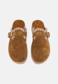 Smeđe suede mule cipele s pletenom teksturom svijetlo ružičaste boje uz otvor, s kopčom i teksturiranom potplatom.