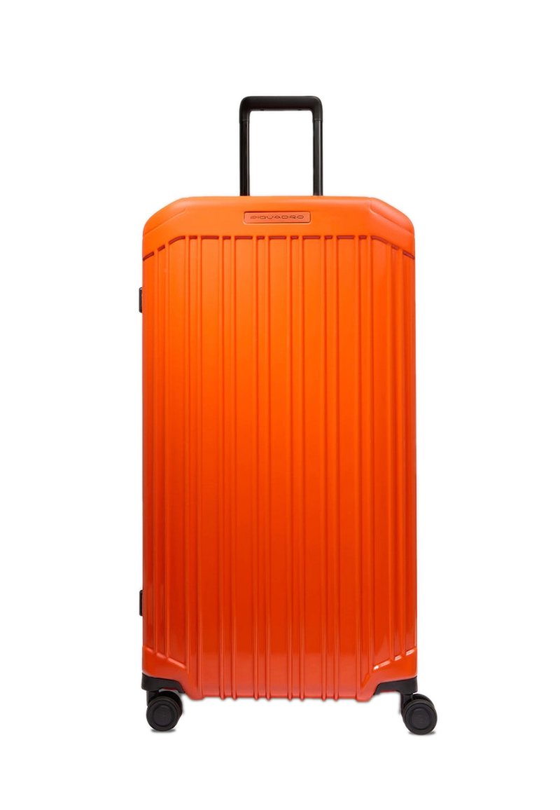 Orangener Hartschalen-Koffer mit vertikalen Rillen, schwarzen Akzenten und einem ausziehbaren Griff. Verfügt über vier Drehrollen für einfache Mobilität.