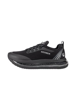Schwarzer Giesswein Sneaker mit transparenter, gepolsterter Sohle, Schnürung und Branding an der Seite und Ferse.