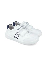 Zapatillas blancas con acentos azules, fabricadas en un material sintético suave, con dos correas de Velcro y un logo en el lateral. Punta redondeada y suela de goma.