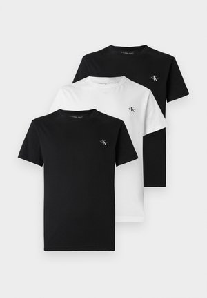 Három póló: egy fekete, egy fehér, mindkettő puha pamutból. Kerek nyakú, rövid ujjú, és kis logó a mellkason. Klasszikus szabású.