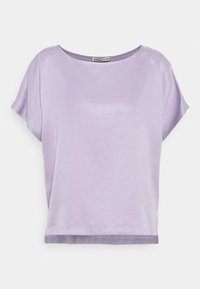 Blusa lavanda a maniche corte con scollatura rotonda e vestibilità ampia, esposta su uno sfondo bianco uniforme.