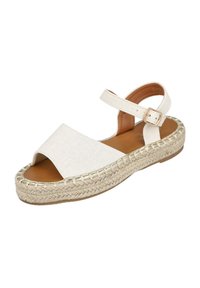 Sandalia de tela blanca con punta abierta, tira en el tobillo y ribete metálico. Presenta una plantilla de yute trenzado y suela de goma plana.