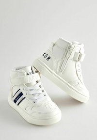 Weisse High-Top-Sneaker aus strukturiertem Leder mit Reißverschluss, Klettverschluss und navyblauen Streifen. Branding auf der Seite.