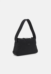 Sac à main noir en tissu lisse avec une forme structurée, doté d'une fermeture éclair et d'une large poignée texturée.