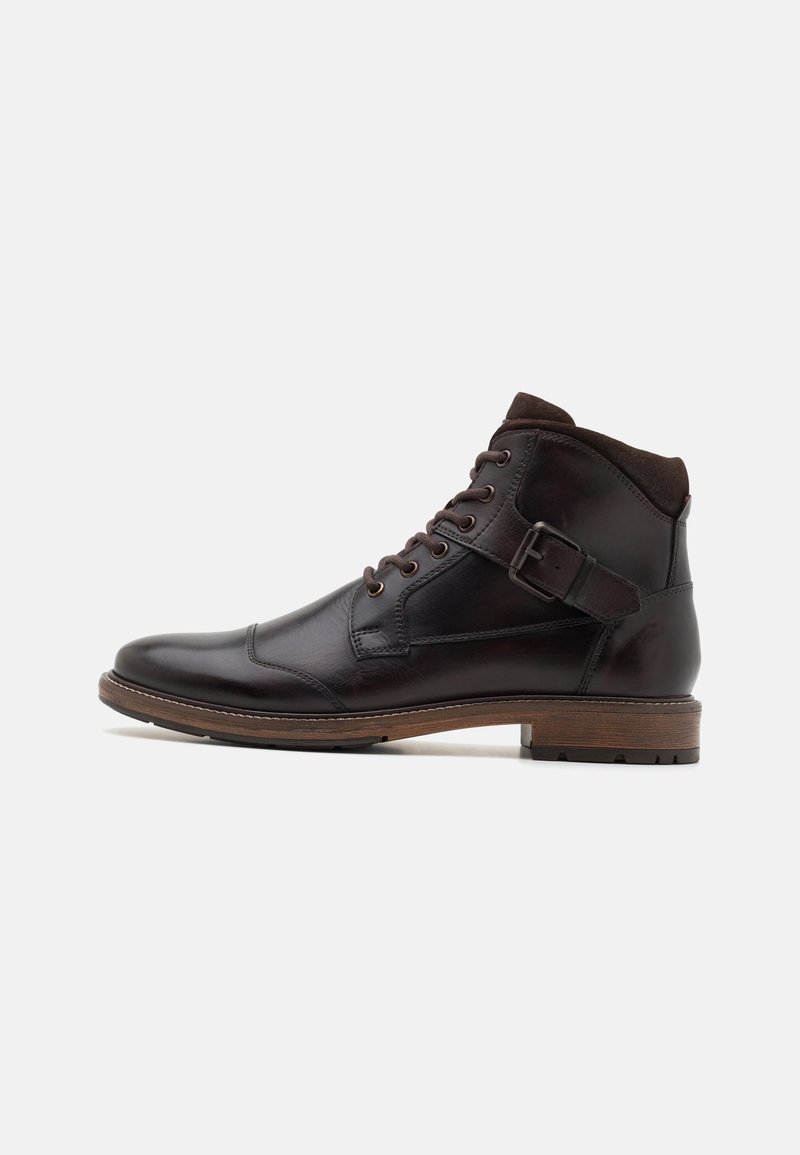 Botas de cuero marrón hasta el tobillo con un diseño de cordones, detalle de hebilla lateral y una suela texturizada marrón. Parte superior lisa con una construcción robusta.