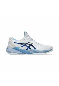 Chaussure de sport blanche avec des accents bleus, présentant un dessus en maille, une semelle rembourrée et un logo noir distinctif. Design basse pour plus de flexibilité.