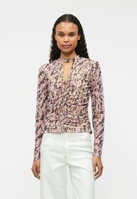 Bluzka z długim rękawem, w różowo-brązowy wzór, z dekoltem w kształcie klucza, zdobieniami marszczenia oraz miękkim, gładkim materiałem. Zaprojektowana w dopasowanym fasonie.