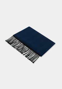 Granatowy tkany pled z wzorem jodełki, wykończony długimi czarnymi frędzlami na krawędziach. Prostokątny, miękka tekstura.