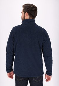 Pullover in pile blu navy con colletto alto, superficie testurizzata e maniche lunghe, caratterizzato da un orlo leggermente allungato sul retro e vestibilità casual.
