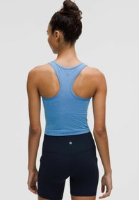 Jasnoniebieski, prążkowany top na ramiączkach z tyłem w stylu racerback; zestawiony z czarnymi szortami z wysokim stanem z logo z tyłu.