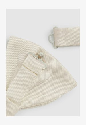 Gaišs bēšu tauriņš, izgatavots no tekstūrēta auduma ar smalku svītru rakstu. Sudraba metāla klipsi katrā pusē pievienošanai.