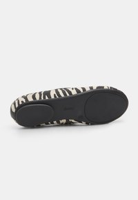 Fekete-fehér zebra mintás lapos cipő, puha szövet felsőrészsel és gumitalppal, kerek orral és minimalista dizájnnal.