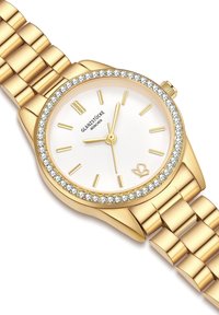 Kuldne käekell valge näo, kristalli kaunistatud äärte ja kullast tundide markeeringutega. Omab läikivat, omavahel seotud metallrihmaga.