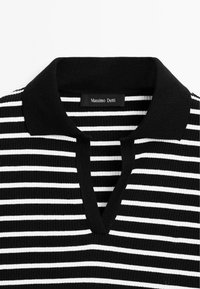 Chemise tricotée à rayures horizontales noires et blanches, avec un col noir et une ouverture en V fendue, dotée d'une étiquette Massimo Dutti à l'intérieur.