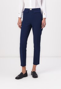 Ναυτικό μπλε κομμένα παντελόνια από μαλακό, ελαστικό ύφασμα. Διαθέτουν στενή εφαρμογή, δύο μπροστινές τσέπες και μέση με χρυσά κουμπιά.