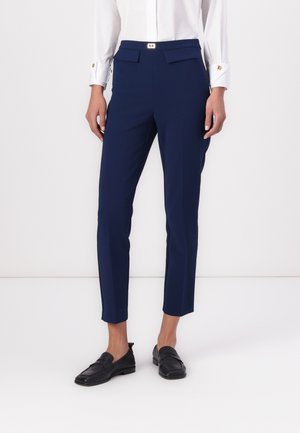 Navy blue tailored trousers made of a smooth, stretchy fabric. Features a slim fit, two front pockets, and a gold-buttoned waistband.