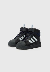 Tênis mid-top pretos com detalhes azuis, listras brancas, biqueira de borracha texturizada e sola de borracha com padrão. Design com atacadores e faixa ajustável.