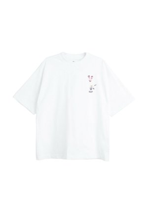 Biały t-shirt z krótkim rękawem z małymi różowymi i czarnymi twarzami zwierząt oraz napisem „huh?” na lewej piersi.