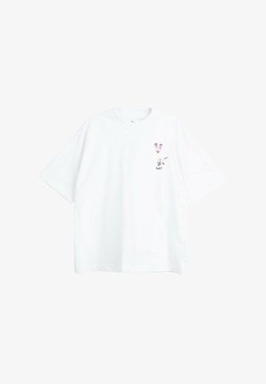 Biały t-shirt z krótkim rękawem z małymi różowymi i czarnymi twarzami zwierząt oraz napisem „huh?” na lewej piersi.