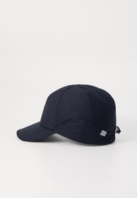 Navy blue cap with a curved brim, quilted texture, adjustable strap on side, and a small label on the lower edge.