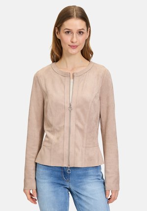 Giacca in suede color beige chiaro con scollatura rotonda e chiusura con zip. Presenta una silhouette aderente e dettagli di cucitura sottili. Maniche lunghe.