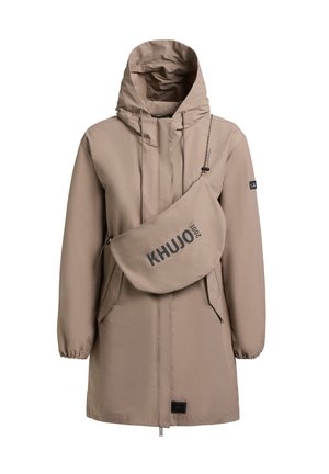 Smėlio spalvos ilga striukė su gobtuvu, užtrauktuku priekyje ir elastingomis rankogaliais, derinama su to paties dizaino per petį nešiojama rankine su užrašu „KHUJO 2001“.