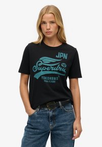 Sort bomulds T-shirt med turkise grafiske bogstaver og logo, rund halsudskæring, korte ærmer og afslappet pasform.
