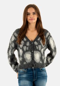 Grijze en witte gebreide cardigan met een v-hals, lange mouwen en vijf zwarte knopen, met een zachte, gestructureerde uitstraling.