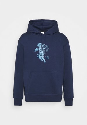Sweat à capuche bleu marine avec poche avant, graphique chérubin bleu clair tenant des fleurs, et texte "NIKE SB" sur la poitrine.