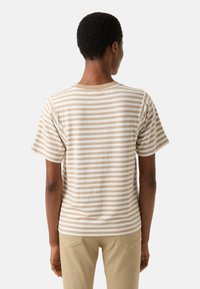 Striped t-shirt in beige and white cotton with a relaxed fit, short sleeves, and a crew neckline, showing back view.
