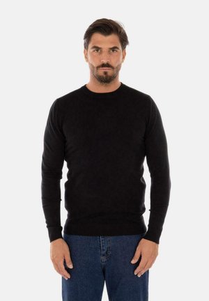 Maglione nero a maglia con scollatura rotonda e maniche lunghe. Presenta polsini e orlo a costine. Abbinato a jeans blu.