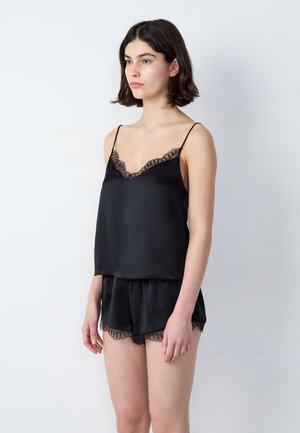 Pajamas en satin noir comprenant un débardeur à bretelles fines avec dentelle et un short assorti, tous deux conçus avec une texture lisse et une coupe décontractée.