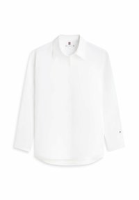 Camisa blanca de manga larga con botones, cuello, logo bordado sutil en el pecho y pequeño logo de bandera en el puño izquierdo.