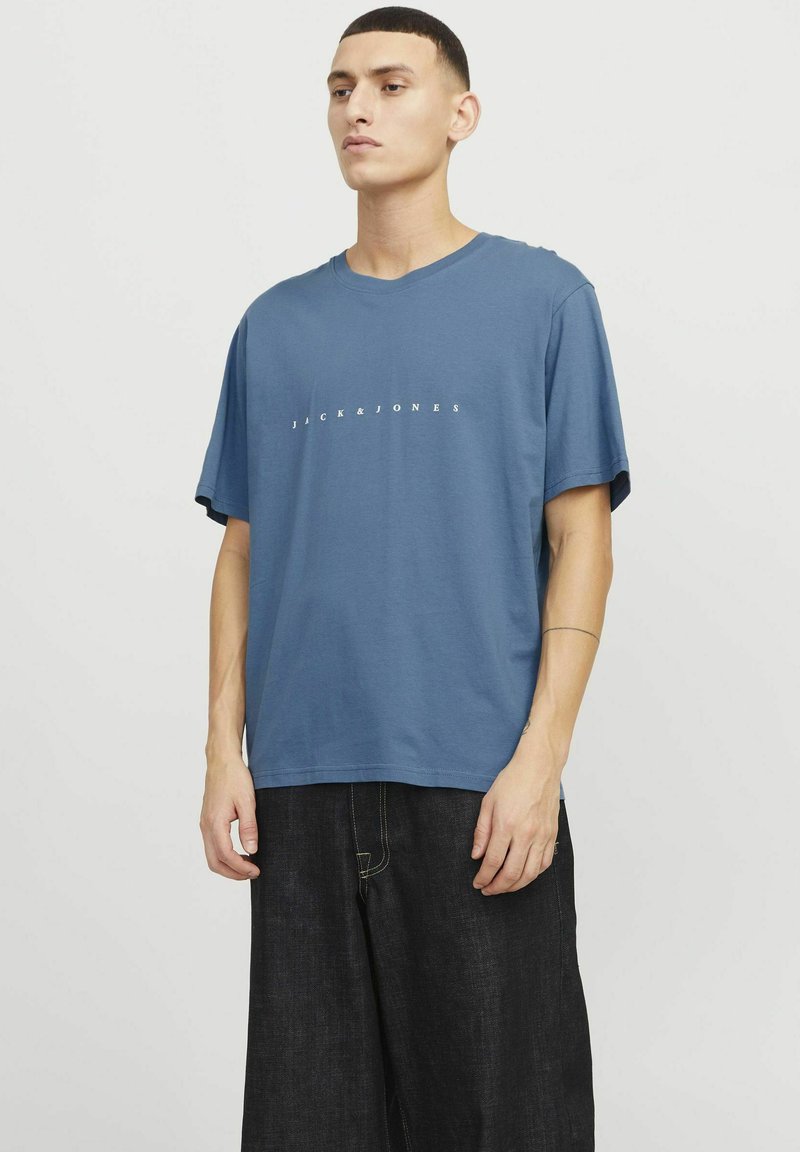 Blaues Baumwoll-T-Shirt mit lockerer Passform und kurzen Ärmeln. Mit dem weißen Drucktext "JACK & JONES" auf der Brust. Sanfte Textur.