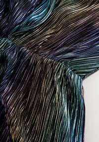Tessuto lucido con sottili strisce ondulate in colori iridescenti, tra cui nero, blu e oro, che creano un aspetto testurizzato e stratificato.