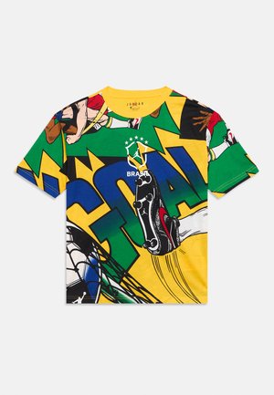 Camiseta colorida con temática de fútbol, con jugadores en estilo cómic, un taco pateando un balón, texto "GOAL" y emblema de Brasil con corona y estrellas.