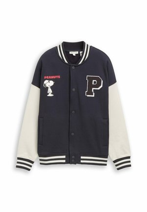 Veste universitaire bleu marine et blanche avec poignets et col rayés, Snoopy du dessin animé Peanuts sur la poitrine gauche, texte rouge "PEANUTS" et écusson lettre noire "P" sur le côté droit.