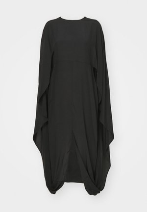 Mustmust särk, mis on valmistatud kerge kangast. Omab ümarat kaelust, voolavaid varrukaid, lõdva lõikega ja drapeeritud disaini koos kogutud detailidega.