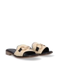 Woven beige slides with black accents, featuring a wide toe strap, gold hardware rings, and a low, brown-toned heel.