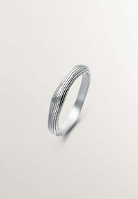 Anillo de plata con un diseño ondulado, que presenta surcos horizontales a lo largo de su superficie. Interior suave, forma minimalista y acabado pulido.