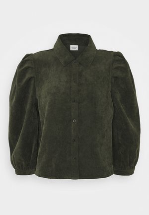 Tamnozeleni kord šshirt s ovratnikom, napučenim rukavima i gumbićima sprijeda. Tekstuirana tkanina s vertikalnim rebrima, kroj prilagođen tijelu.