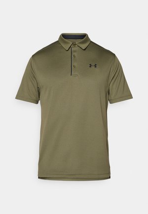 Oliivivihreä polo-paita, jossa on teksturoitu kangas, kolme nappia ja tumma laivastonsininen yksityiskohta. Rintamalla on brodeerattu logo.