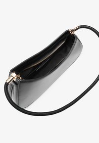 Black leather handbag with a smooth texture, featuring a zippered opening and a thin, braided strap. Interior lined with black fabric.