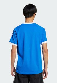 Blue short-sleeve T-shirt with a white crew neckline and sleeve accents, smooth fabric, and a relaxed fit. No visible logos or patterns.