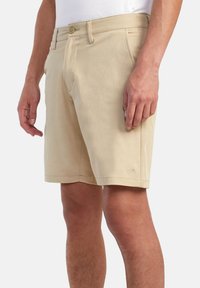 Beige shorts made of cotton blend fabric, featuring a classic fit, front pockets, a button closure, and a subtle brand logo on the hem.