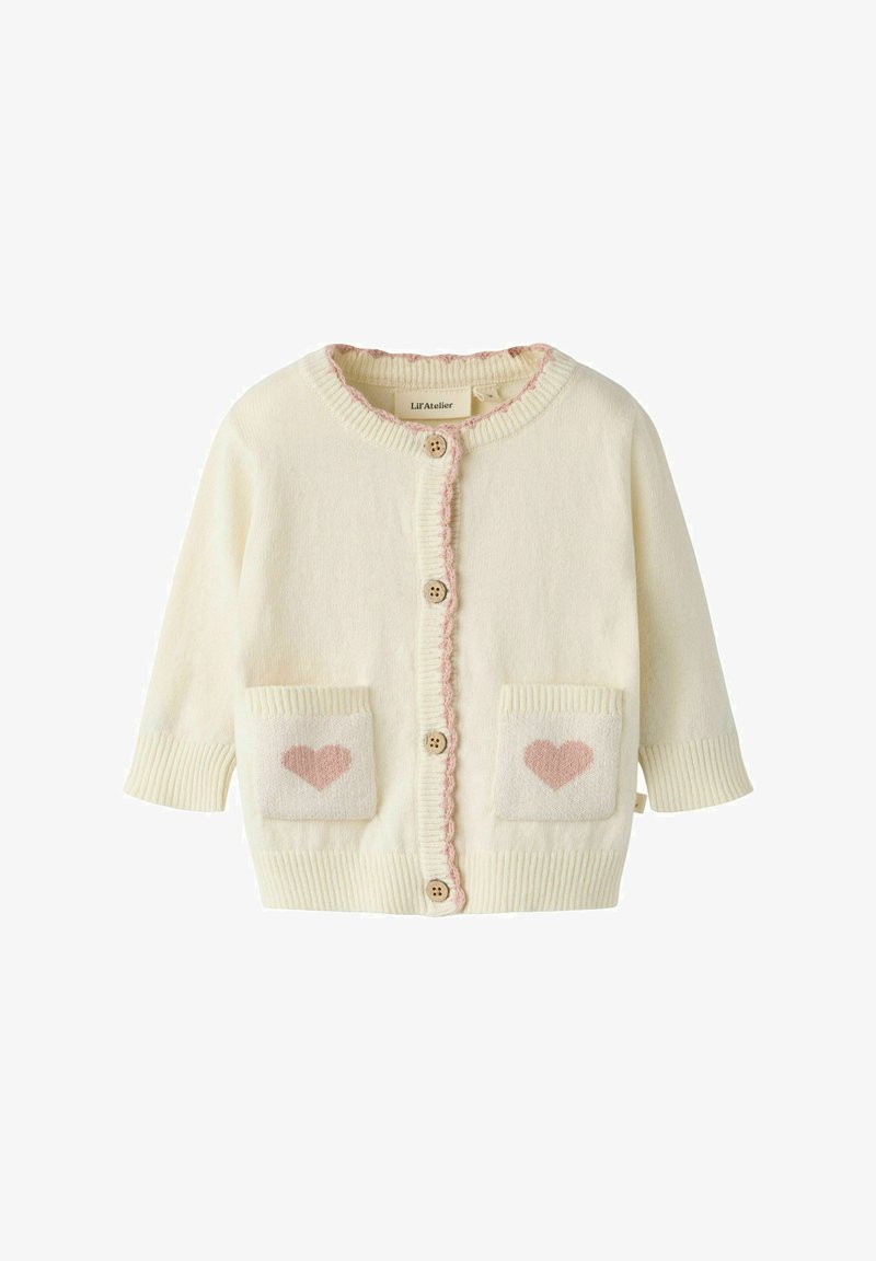 Cardigan bébé couleur crème avec patchs en forme de cœur roses sur les poches avant, boutons en bois et bordure rose le long de la ligne de boutons et du col.