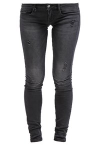 Smal svarta jeans i denim med slitna lappar och en klassisk femficksdesign. Tyget har en mjuk yta och en lätt lyster.