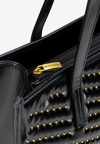 Schwarze Leder-Handtasche mit goldenen Nieten, Reißverschluss mit goldfarbenen Beschlägen und zwei langen Tragegriffen.